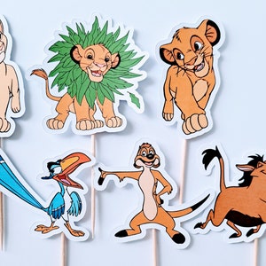 May include: Set of six Lion King character cupcake toppers. The toppers feature Simba, Nala, Zazu, Timon, Pumbaa, and a lion with a green mane. The toppers are printed on white cardstock and have wooden sticks attached to the back.
