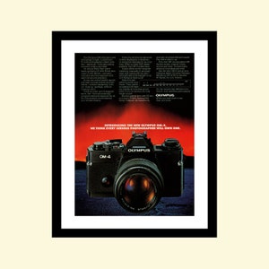 May include: A black Olympus OM-4 camera with a silver lens is shown against a red and black background. The text "Introducing the new Olympus OM-4. We think every serious photographer will own one." is printed below the camera.