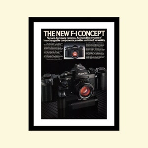 Peut inclure: Une publicité vintage pour le système de caméra Canon F-1. La publicité présente un appareil photo Canon F-1 noir et argent avec un objectif. Le texte dit "Le nouveau concept F-1. Pas un, mais plusieurs appareils photo. Un système incroyable de composants interchangeables offre une polyvalence illimitée."