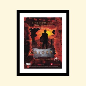 以下が含まれることがあります： Rygar: The Legendary Adventure のビデオゲーム広告。画像には、夕焼けの背景を前に、盾を持った戦士のシルエットが描かれています。戦士の上に「In the darkest hour, a hero is reborn.」というテキストが表示されています。戦士の下にゲームタイトル「Rygar: The Legendary Adventure」が表示されています。ゲームタイトルの下に「The journey begins this November.」というテキストが表示されています。