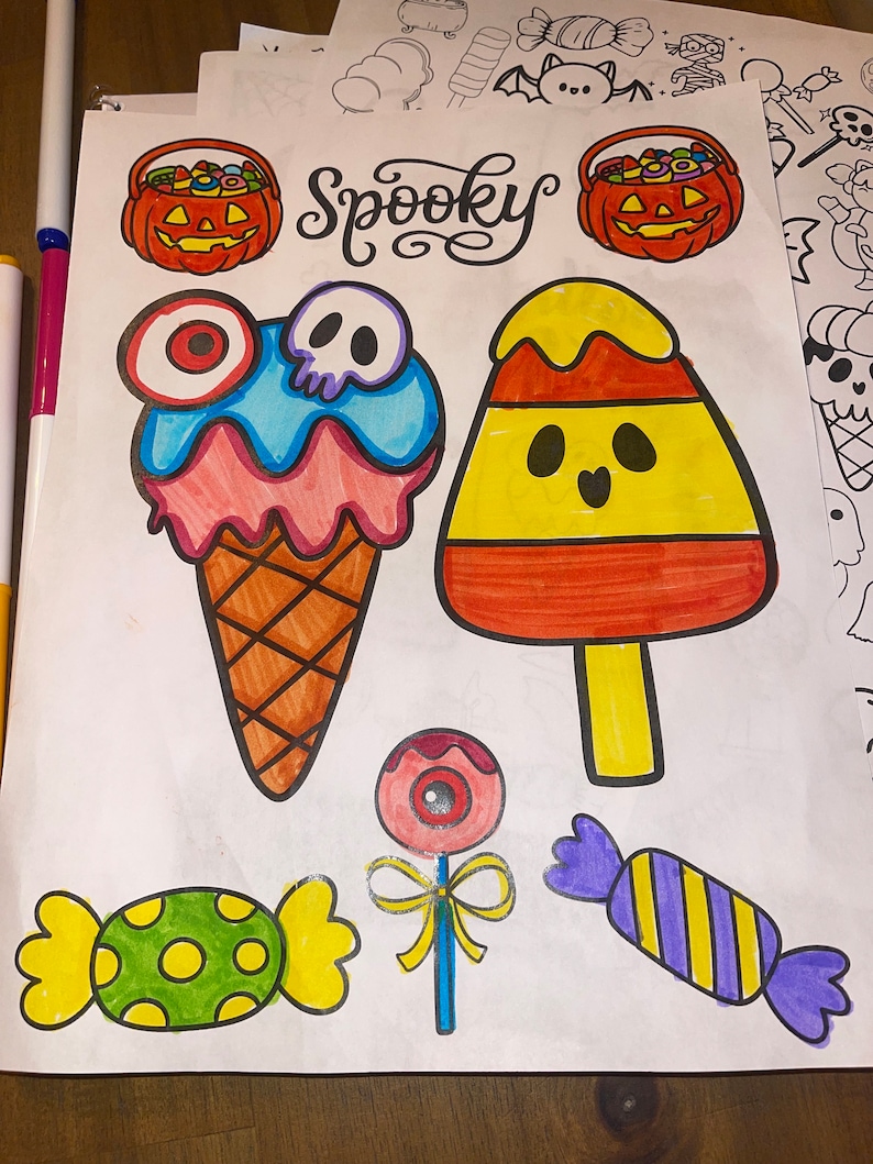 May include: A coloring page with the word "Spooky" in a whimsical font. The page features various Halloween-themed images, including a candy corn, a pumpkin bucket, an ice cream cone with a skull, a lollipop with an eye, and two candy pieces.