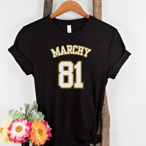 May include: Black t-shirt with a gold and white graphic that says "Marchy 81"