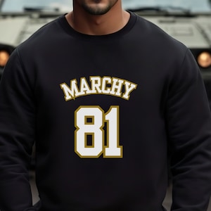 May include: Black sweatshirt with gold lettering that reads "Marchy 81".