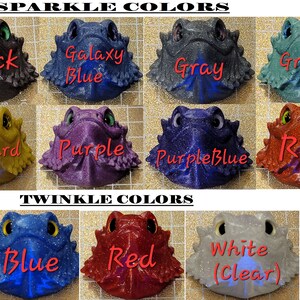 May include: A chart showing 10 different colors of glitter resin bearded dragon figurines. The colors are: black, galaxy blue, gray, green, mustard, purple, purple blue, red, blue, and white (clear).
