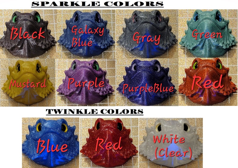 May include: A chart showing 10 different colors of glitter resin bearded dragon figurines. The colors are: black, galaxy blue, gray, green, mustard, purple, purple blue, red, blue, and white (clear).