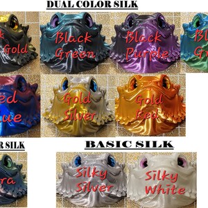 May include: A collection of 3D printed figurines with different color combinations. The figurines are of a bearded dragon with a textured surface. The colors include black, dark gold, green, purple, blue, red, gold, silver, and white. The text "Dual Color Silk", "Tricolor Silk", and "Basic Silk" is displayed above the figurines.