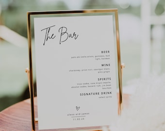 May include: A gold-framed sign with the text "The Bar" in black cursive lettering. The sign lists various beer, wine, and spirit options, including pale ale, chardonnay, pinot noir, tequila, and bourbon. The sign also includes the text "alexa and james" and the date "11.02.23".