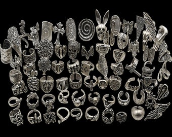 May include: A collection of silver-toned adjustable rings with various designs, including skulls, crosses, butterflies, and other abstract patterns.