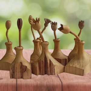 Könnte beinhalten: Eine Sammlung handgefertigter Holzblumenskulpturen. Jede Skulptur zeigt ein einzigartiges Blumendesign auf einem vasenförmigen Sockel. Die natürliche Holzmaserung und die unterschiedlichen Blütenformen schaffen eine rustikale, künstlerische Darstellung.