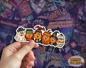 May include: A die-cut vinyl sticker featuring six orange McDonald's chicken nuggets dressed in Halloween costumes: a ghost, Frankenstein's monster, a vampire with a bat, a jack-o'-lantern, a witch, and a mummy, all with smiling faces.