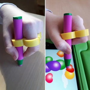 May include: A pink and green stylus with a yellow finger holder for use with a tablet or phone.