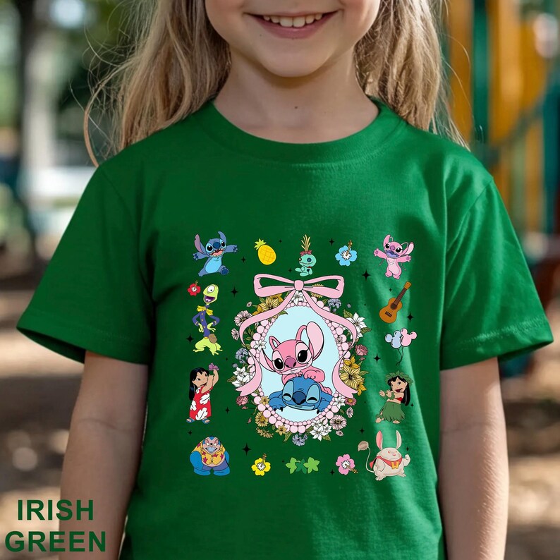 May include: Green t-shirt with a colourful graphic featuring characters from the animated movie Lilo & Stitch. The design includes Stitch, Angel, and other characters, surrounded by flowers and a pink bow. The text "IRISH GREEN" is printed at the bottom.