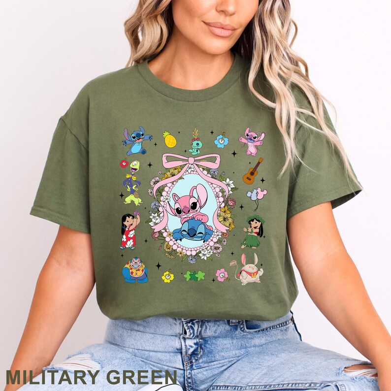 May include: Military green t-shirt with a vibrant graphic of animated characters. The design showcases a central oval frame with two characters, surrounded by other characters and floral details. The text "MILITARY GREEN" is displayed at the bottom of the shirt.