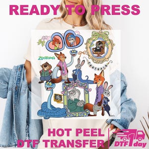 May include: A white t-shirt with a vibrant graphic of Zootopia characters. The design showcases detailed illustrations of animal characters, with the word "Zootopia" in the centre. The phrases "READY TO PRESS" and "HOT PEEL DTF TRANSFER" are also printed on the shirt.