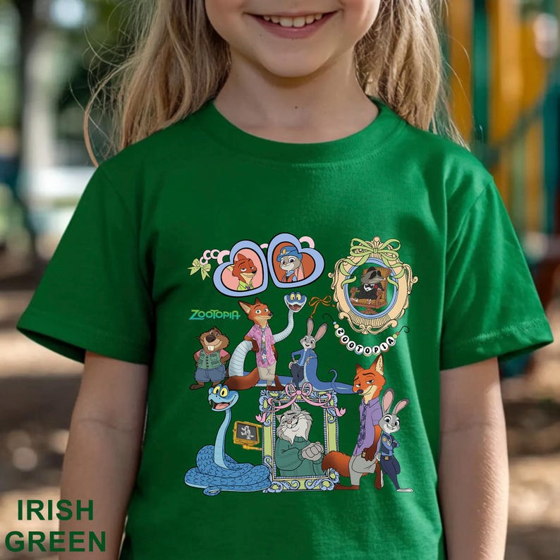 May include: A green t-shirt with a graphic of characters from the film Zootopia. The design includes animal characters in frames and the film's title. The words "Irish Green" are printed at the bottom of the shirt. The shirt is a vibrant green colour.