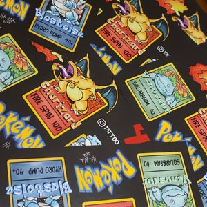 May include: Close-up of several colorful Pokemon trading cards featuring Charizard, Blastoise, and Venusaur. The cards have a black background with yellow borders and feature the Pokemon's names and attack moves. The cards are arranged in a random order.