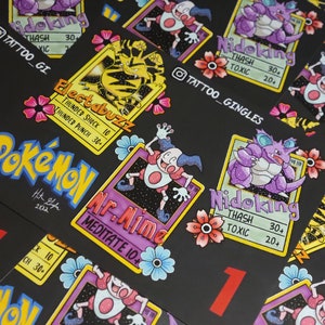 May include: A set of six Pokemon trading cards featuring different Pokemon characters. The cards are black with colorful illustrations of the Pokemon characters. The cards have the Pokemon's name, type, and attack stats. The cards are numbered 1 and 2.