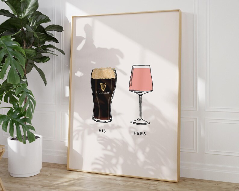 May include: A framed print featuring illustrations of two drinks: a pint of Guinness and a pink cocktail in a stemmed glass. The words "HIS" and "HERS" are printed below the respective glasses. The artwork has a minimalist style.