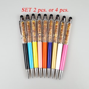 May include: A collection of colorful stylus pens with a clear barrel filled with gold-colored glitter. The pens have black touch tips and silver accents. The text "SET 2 pcs. or 4 pcs." is in red.