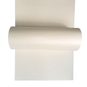 Op de afbeelding: Een rol wit papier, gedeeltelijk uitgerold, met het gladde, witte oppervlak van het papier.