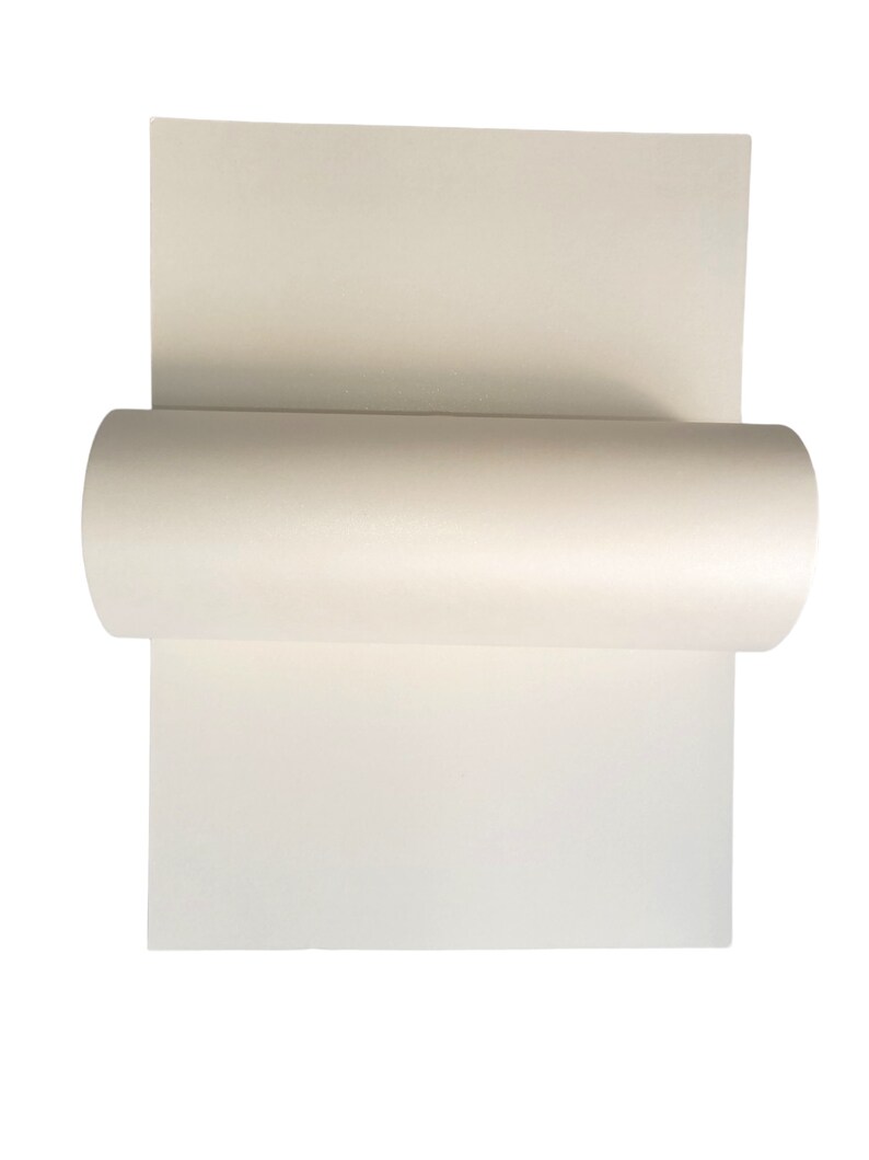 Op de afbeelding: Een rol wit papier, gedeeltelijk uitgerold, met het gladde, witte oppervlak van het papier.