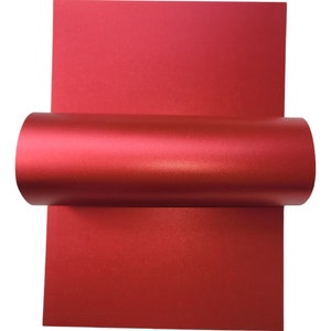 Op de afbeelding: Een rol rood metallic papier. Het papier heeft een subtiele glans en is perfect voor knutselen of scrapbooking.