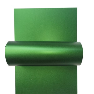 Op de afbeelding: Een rol groene metallic cadeaupapier. Het papier heeft een subtiele glans en is perfect om geschenken een vleugje elegantie te geven.