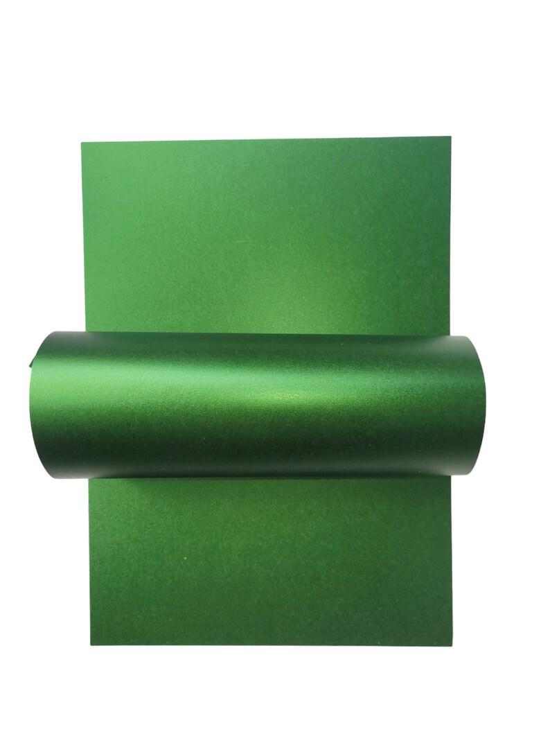 Op de afbeelding: Een rol groene metallic cadeaupapier. Het papier heeft een subtiele glans en is perfect om geschenken een vleugje elegantie te geven.