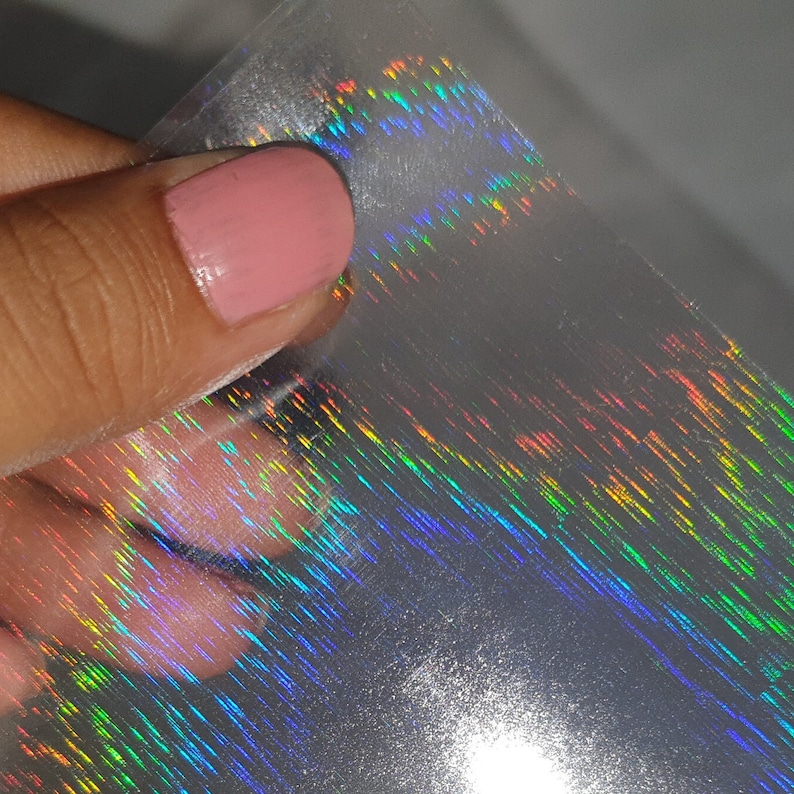 May include: A sheet of iridescent holographic film with a rainbow pattern. The film is translucent and has a subtle shimmer.