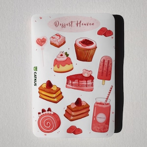 May include: A sheet of pink and white stickers featuring various desserts, including cakes, cupcakes, popsicles, and a strawberry smoothie. The stickers are decorated with hearts and the text "Dessert Heaven".
