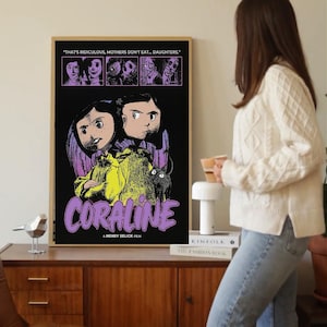 Puede incluir: Un póster enmarcado de la película "Coraline" con un fondo negro e ilustraciones de personajes y el título de la película en morado. El póster incluye el texto "THAT'S RIDICULOUS, MOTHERS DON'T EAT... DAUGHTERS." y "A HENRY SELICK FILM."