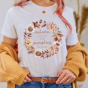 May include: White t-shirt with a floral wreath design and the text "autumn leaves and pumpkins please".