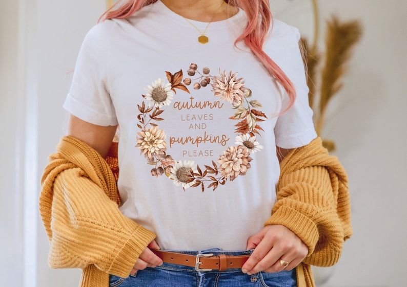May include: White t-shirt with a floral wreath design and the text "autumn leaves and pumpkins please".