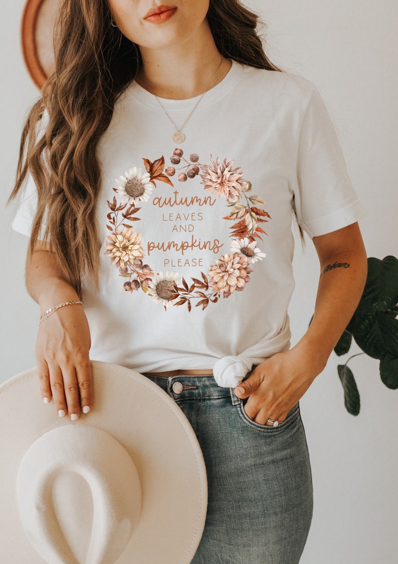 May include: White t-shirt with a floral wreath design and the text "autumn leaves and pumpkins please".