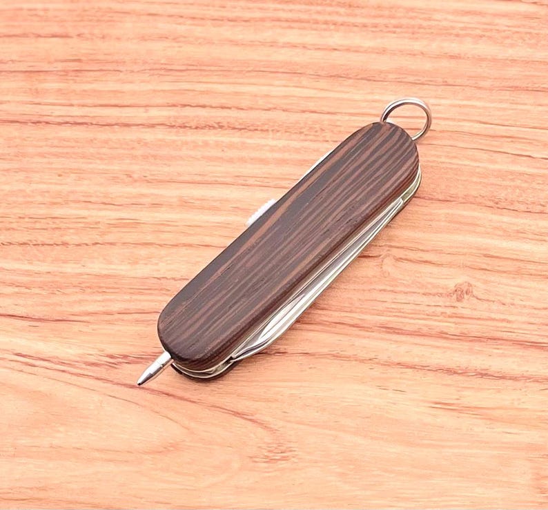 May include: A brown wood-handled pocket knife with a silver blade and a silver ring on the handle.