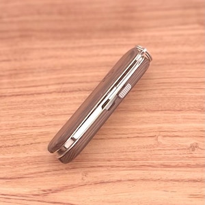 May include: A brown wood-handled pocket knife with a silver metal blade and a silver metal lock.