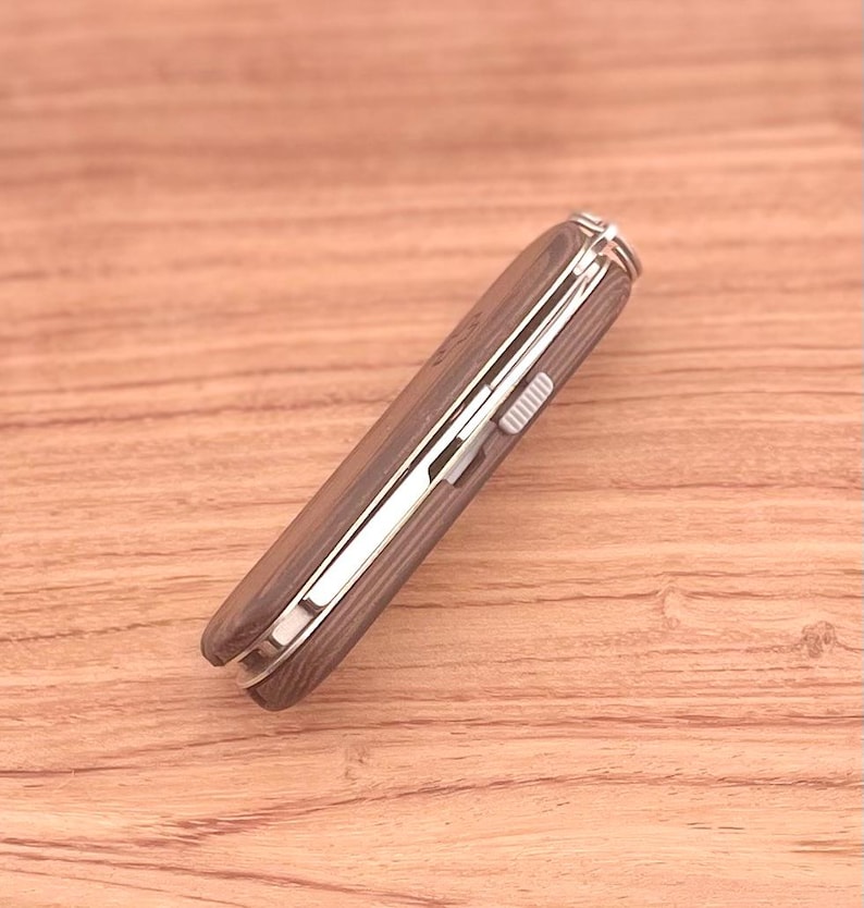May include: A brown wood-handled pocket knife with a silver metal blade and a silver metal lock.