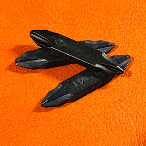 May include: Three black metal screwdriver bits with a silver inscription on one of the bits.