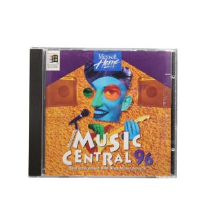 Puede incluir: Un CD-ROM de Microsoft Music Central 96 en una caja transparente. La portada presenta una ilustración estilizada de un músico de cara azul tocando la guitarra y cantando en un micrófono, con el texto "Music Central 96".