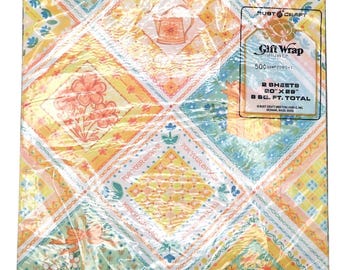 Könnte beinhalten: Vintage Geschenkpapier mit einem Patchwork-Design in Gelb, Orange und Türkis. Das Muster enthält Blumen- und Teekannenmotive. Die Verpackung trägt die Aufschrift "Gift Wrap" und "For Your Shower". Jedes Blatt misst 50.8 cm x 73.7 cm.