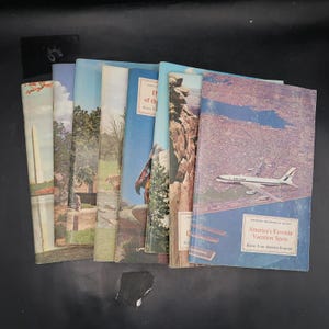 Op de afbeelding: Een verzameling vintage reisgidsboekjes. De covers tonen kleurrijke illustraties van Amerikaanse bezienswaardigheden, landschappen en een United Airlines-vliegtuig. Titels zijn onder meer "America's Favorite Vacation Spots" en "Know Your America Program".
