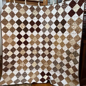 Handmade 4 patch lap quilt (60x61) in brown and beige tones.