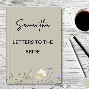 May include: Beige journal with the text 'Samantha Letters to the Bride' and floral illustrations. The journal is on a white wood background.