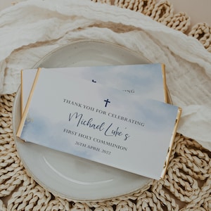 May include: A white and blue watercolor-style thank you card with a gold border. The card says "Thank you for celebrating Michael Luke's First Holy Communion 26th April 2022".