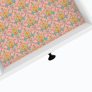 May include: A white drawer with a pink and colorful floral patterned liner. The drawer has a black knob.