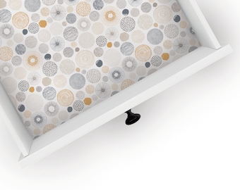 May include: White drawer with a black knob. The inside of the drawer is lined with patterned paper featuring a repeating design of grey, beige, and yellow circles.