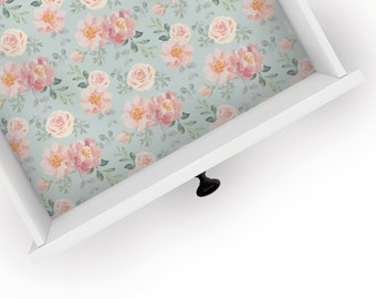 May include: A white drawer with a floral pattern liner. The drawer has a black knob.