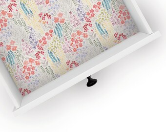 May include: White drawer with a black knob and a floral pattern lining the inside. The pattern features pink, red, blue, and yellow flowers on a light grey background.