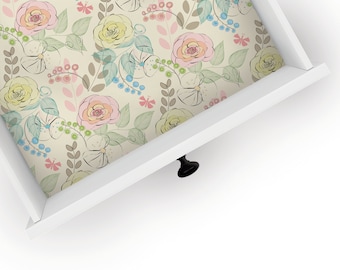 May include: A white drawer with a floral pattern liner. The drawer has a black knob.