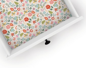 May include: A white drawer with a floral pattern liner. The liner features pink, red, blue, and green flowers, leaves, and birds.